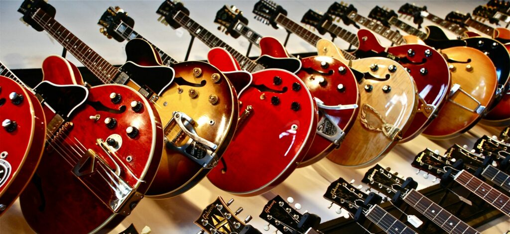 A lot of electric guitars hanging on a wall