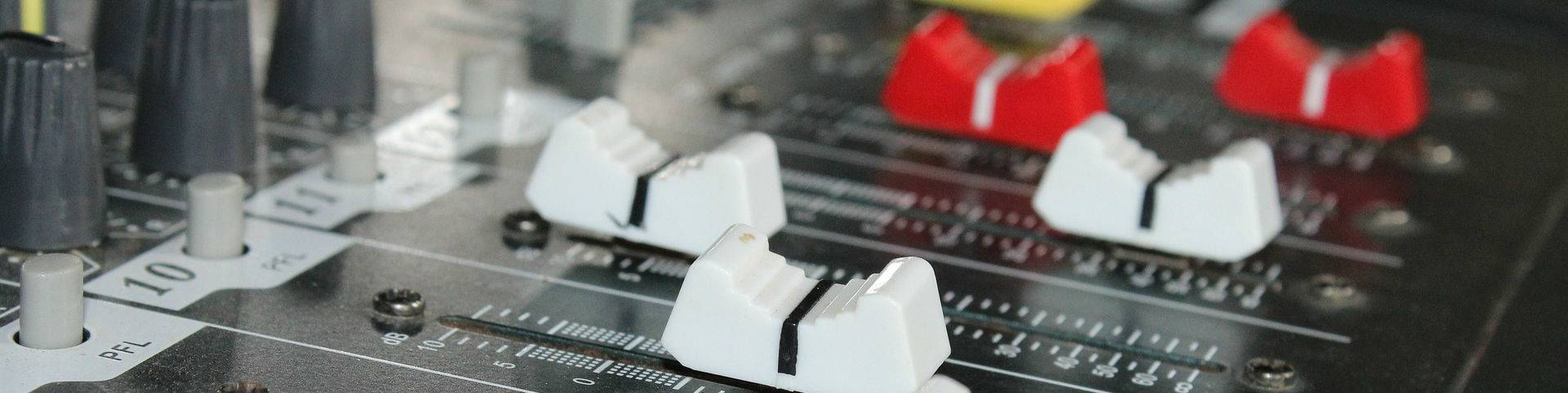 Faders on an analogue desk used for audio summing