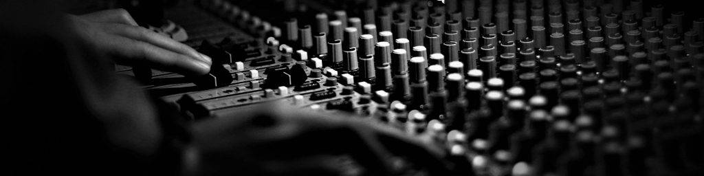 Two hands on a mixing desk